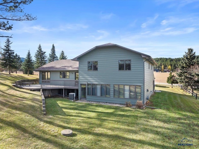 back of house featuring a wooden deck, central AC, and a lawn