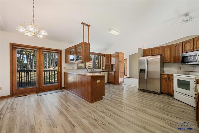 kitchen featuring appliances with stainless steel finishes, decorative light fixtures, kitchen peninsula, and light hardwood / wood-style flooring