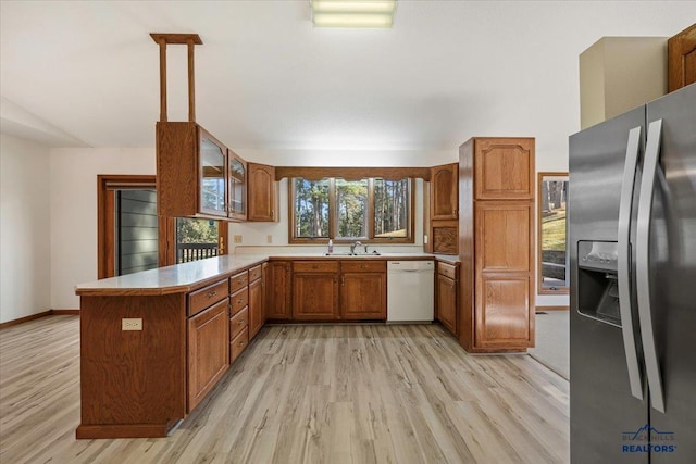 kitchen featuring sink, stainless steel fridge, kitchen peninsula, white dishwasher, and pendant lighting