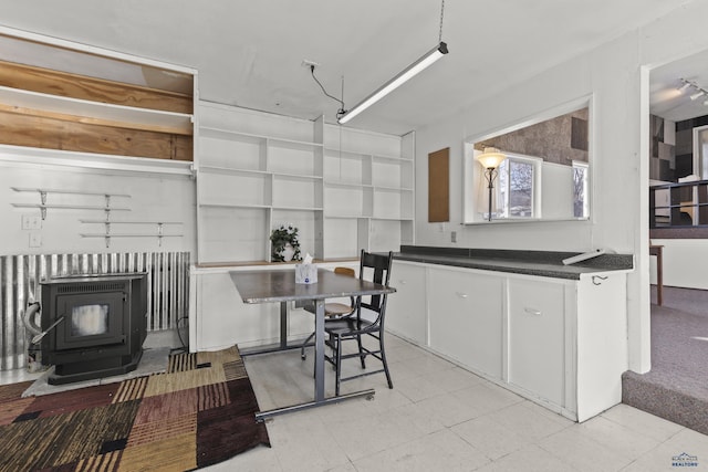 318 4th Ave, Wall, SD 57790 - kitchen featuring white cabinetry and a wood stove