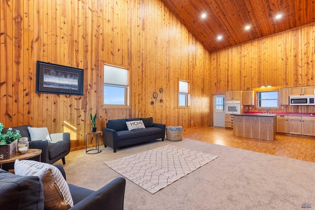 living room featuring wooden ceiling, high vaulted ceiling, light carpet, and wood walls