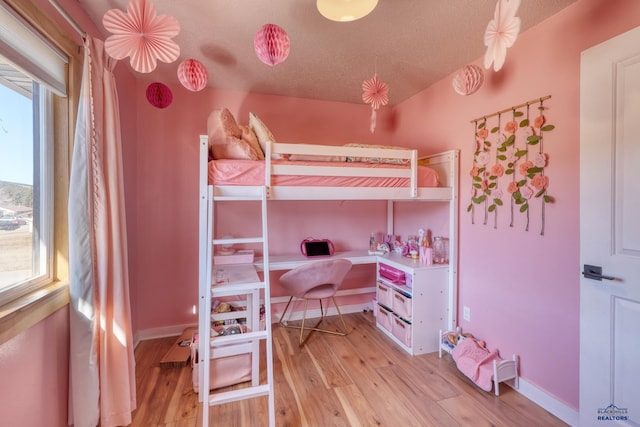 bedroom featuring a textured ceiling and light hardwood / wood-style floors