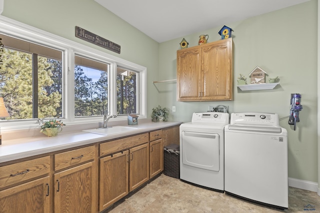 laundry room featuring washer and dryer, sink, and cabinets