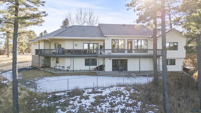 snow covered rear of property with a deck