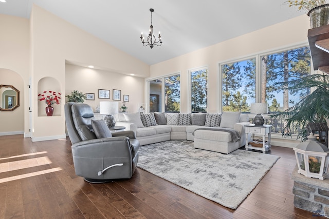 living room featuring high vaulted ceiling, an inviting chandelier, and dark hardwood / wood-style flooring