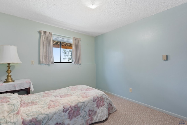 bedroom with carpet and a textured ceiling