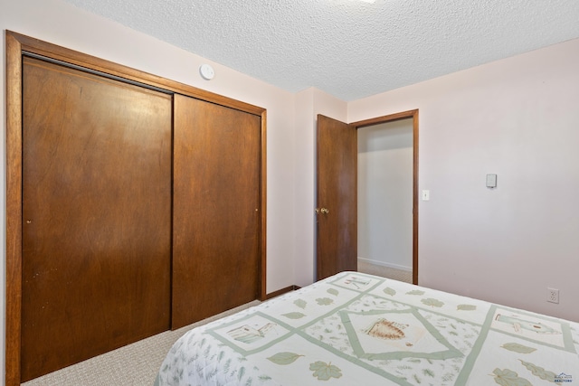 bedroom featuring carpet floors, a closet, and a textured ceiling