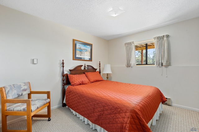 carpeted bedroom featuring a baseboard heating unit and a textured ceiling