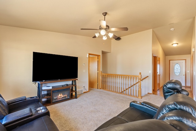 living room with lofted ceiling, ceiling fan, and carpet flooring