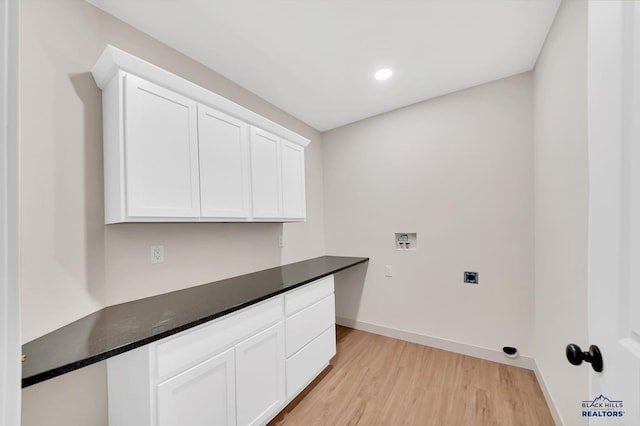 laundry room featuring cabinets, hookup for a washing machine, light hardwood / wood-style flooring, and hookup for an electric dryer