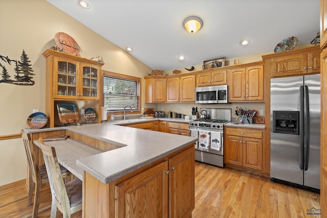 369 Deegan Dr, Hill City, SD 57745 - kitchen with sink, vaulted ceiling, appliances with stainless steel finishes, a kitchen breakfast bar, and light hardwood / wood-style floors