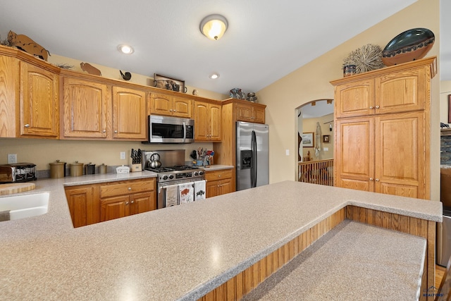 369 Deegan Dr, Hill City, SD 57745 - kitchen featuring sink, a breakfast bar, appliances with stainless steel finishes, vaulted ceiling, and kitchen peninsula