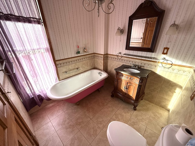 bathroom with vanity, a bath, tile patterned floors, and toilet