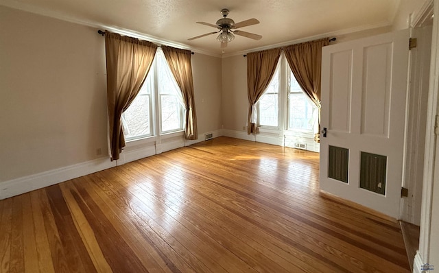 spare room with crown molding, a wealth of natural light, ceiling fan, and light hardwood / wood-style floors