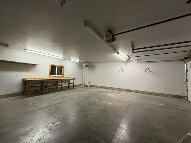 garage featuring a garage door opener, a wall unit AC, and a workshop area