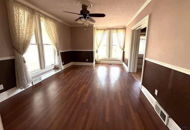 unfurnished room featuring ornamental molding, dark hardwood / wood-style flooring, a textured ceiling, and plenty of natural light