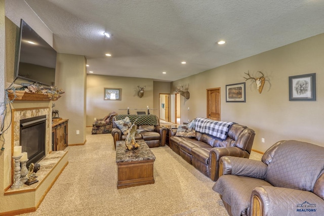 carpeted living room with a premium fireplace and a textured ceiling