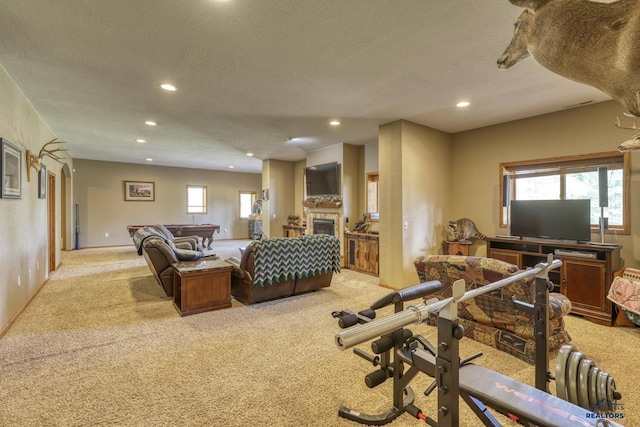 workout room with light colored carpet and a textured ceiling