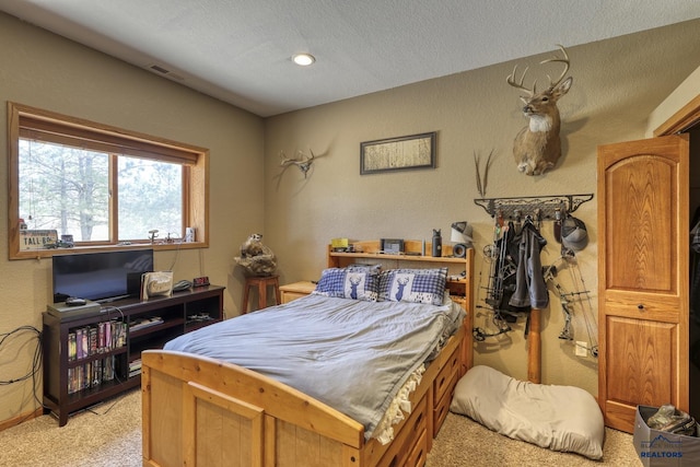 carpeted bedroom featuring a textured ceiling