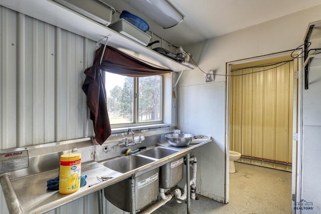 kitchen with a baseboard radiator, sink, and stainless steel counters