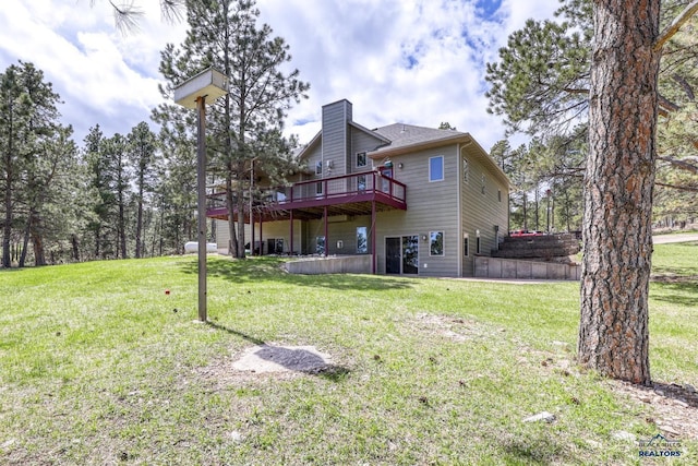 back of house with a wooden deck and a lawn