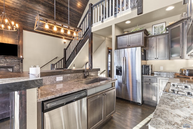 kitchen featuring dark wood-style flooring, stainless steel appliances, wood ceiling, a sink, and light stone countertops