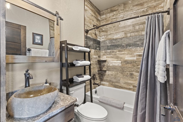 bathroom with a textured wall, shower / bath combo, vanity, and toilet