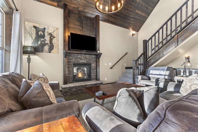 living room with high vaulted ceiling, wooden ceiling, a notable chandelier, a fireplace, and stairway