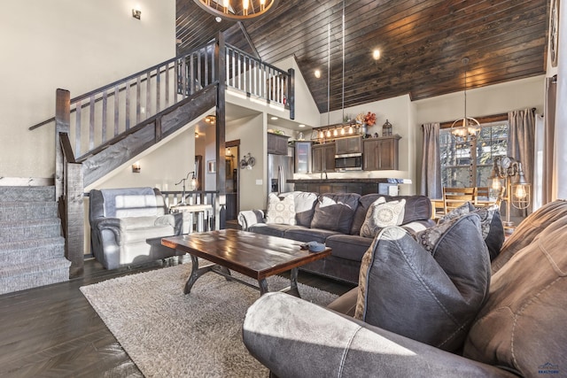 living area with high vaulted ceiling, wooden ceiling, a notable chandelier, and stairs