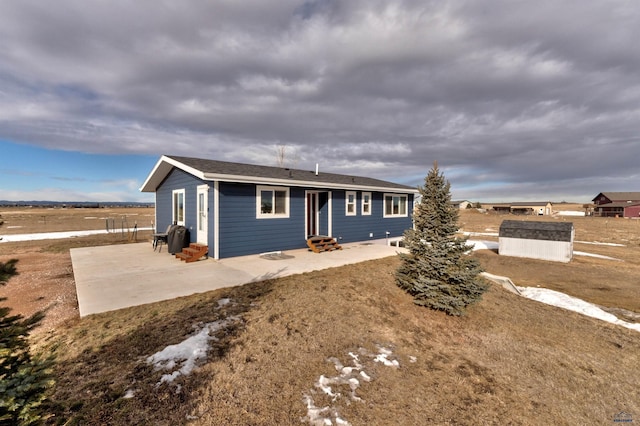 ranch-style house featuring a shed and a patio area