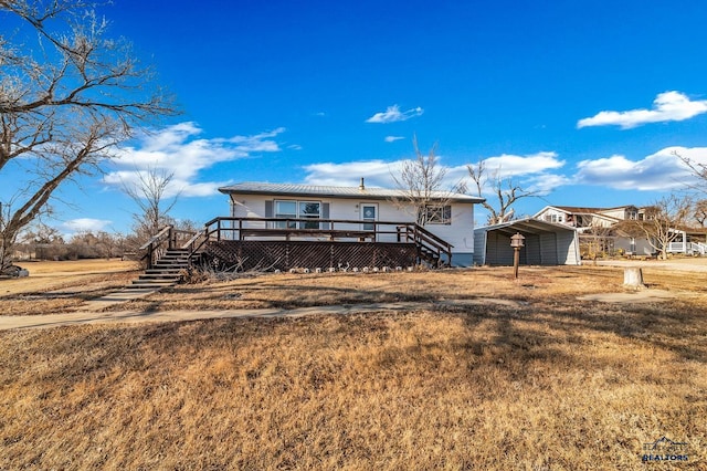 view of front of home with a carport, a deck, and a front lawn