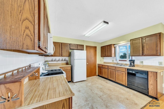 kitchen featuring tasteful backsplash, white appliances, and sink