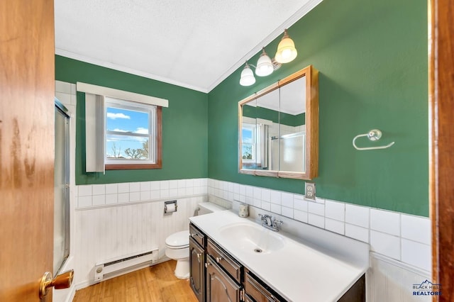 bathroom featuring a shower with door, baseboard heating, vanity, wood-type flooring, and toilet