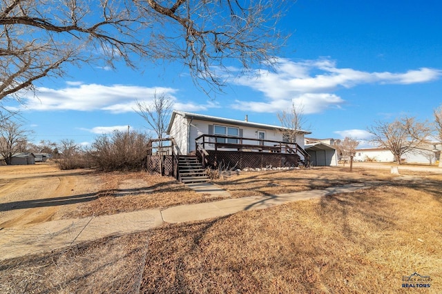 view of front facade featuring a wooden deck and a carport