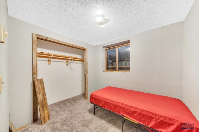 carpeted bedroom featuring a textured ceiling and a closet