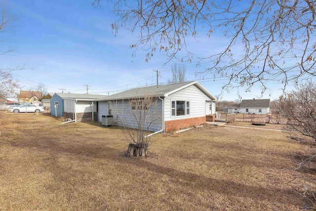 rear view of house with central air condition unit and a lawn