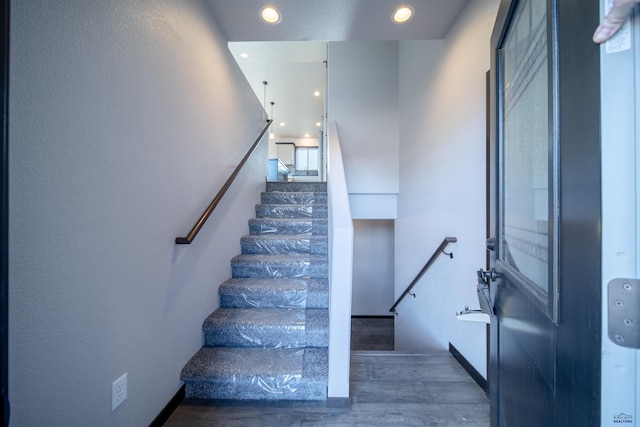 stairs featuring hardwood / wood-style floors