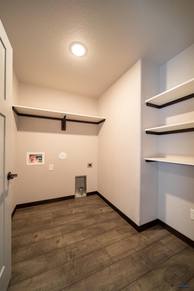 laundry room featuring dark hardwood / wood-style flooring, hookup for a washing machine, hookup for an electric dryer, and a textured ceiling