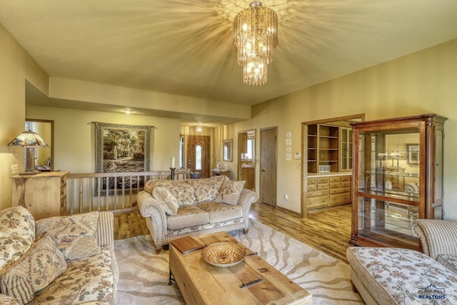 living room with an inviting chandelier and light wood-type flooring