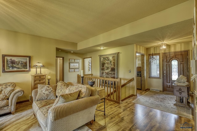 living room featuring light hardwood / wood-style floors and a textured ceiling