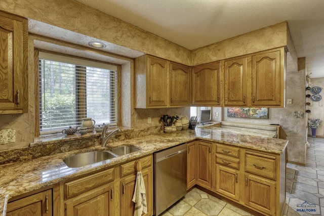 kitchen featuring sink, a textured ceiling, stainless steel dishwasher, kitchen peninsula, and light stone countertops