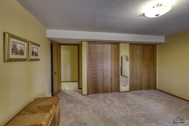 unfurnished bedroom with light colored carpet and a textured ceiling