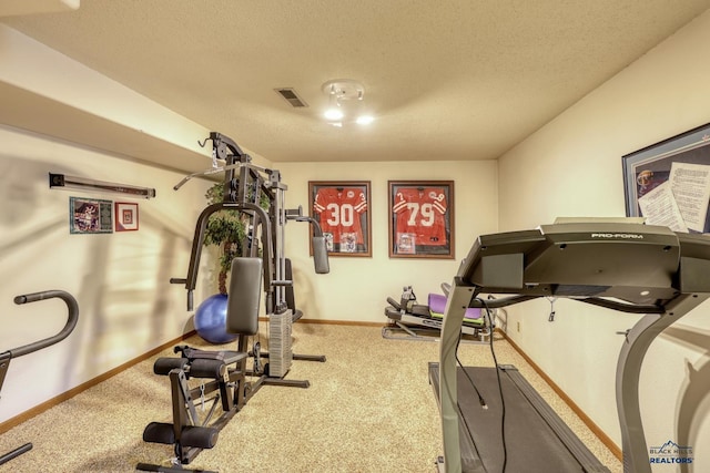 exercise room with carpet and a textured ceiling