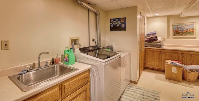 laundry area with cabinets, independent washer and dryer, and sink