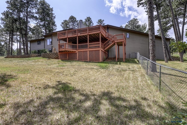 rear view of house with a wooden deck and a yard