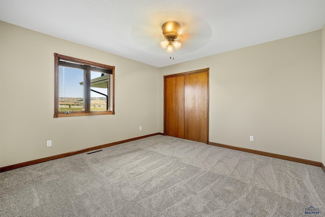 unfurnished bedroom featuring carpet floors, ceiling fan, and a closet