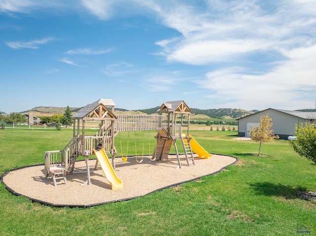 view of playground featuring a mountain view and a yard