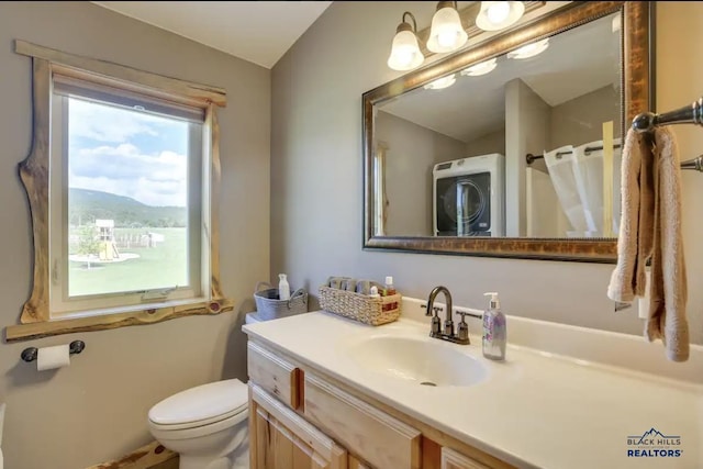 bathroom featuring stacked washer / dryer, vanity, a mountain view, and toilet