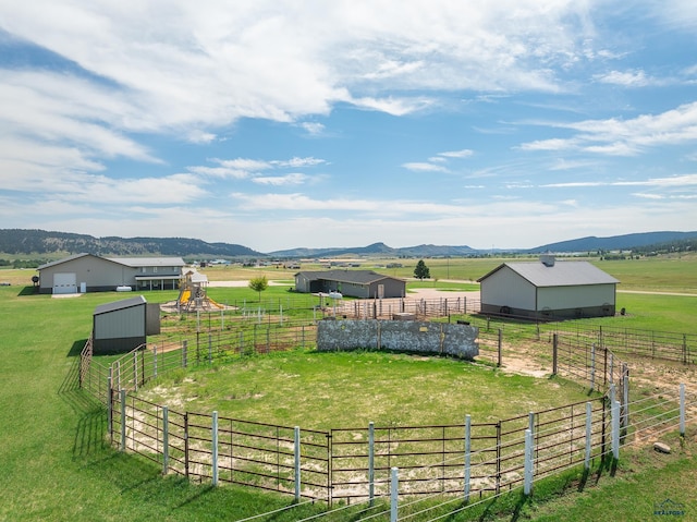 view of yard with an outdoor structure, a mountain view, and a rural view