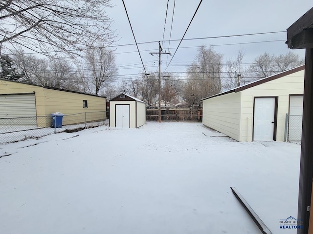 yard covered in snow with a storage shed